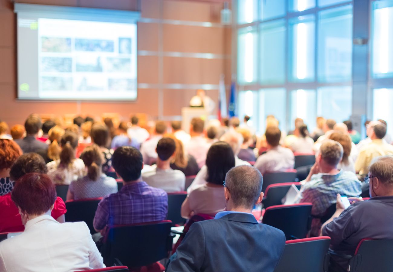 Rear view of a conference room filled with people viewing a presentation